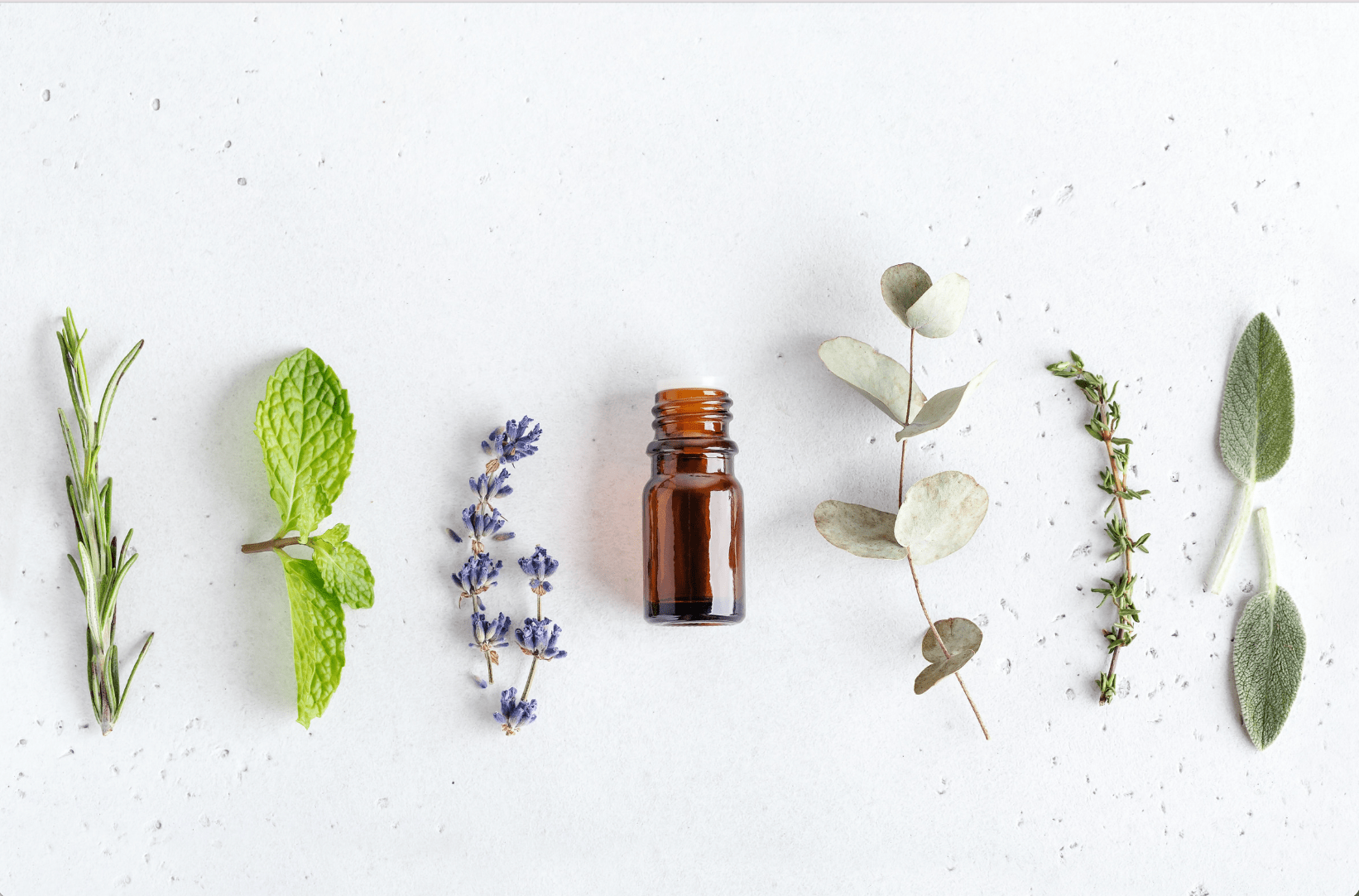 a small brown bottle with leaves and lavender for scent therapy